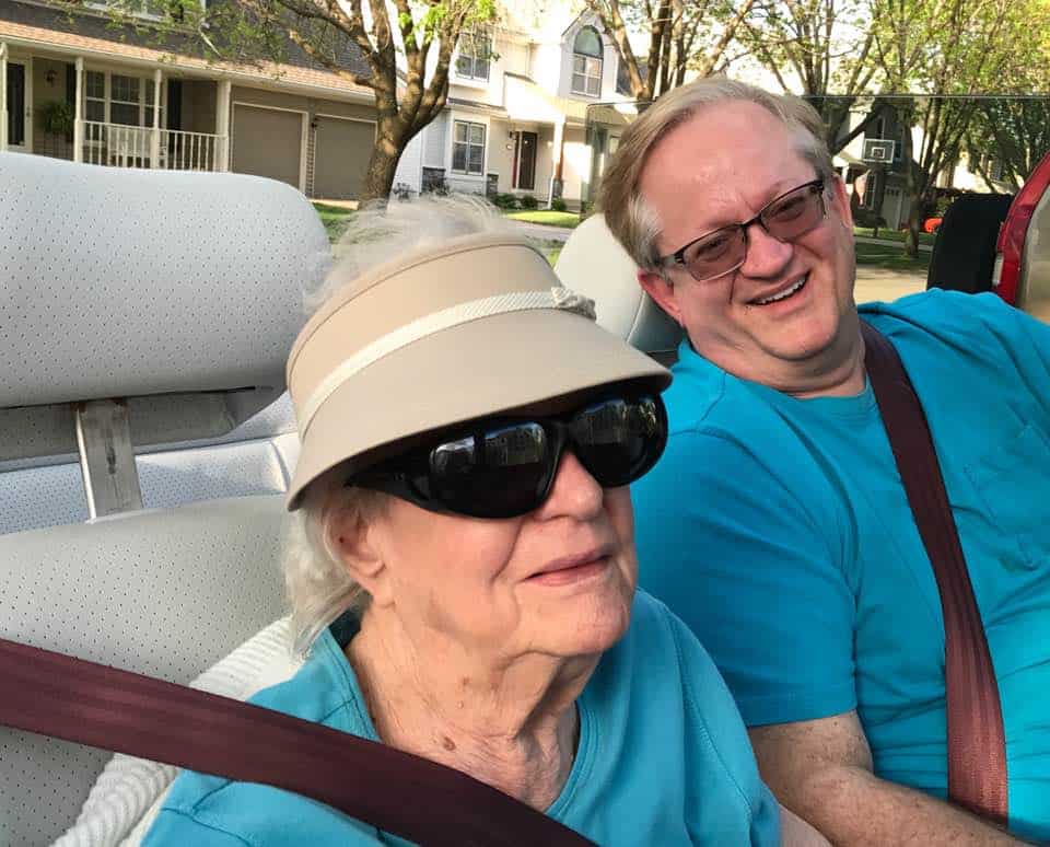 a man and woman sitting in a car and smiling